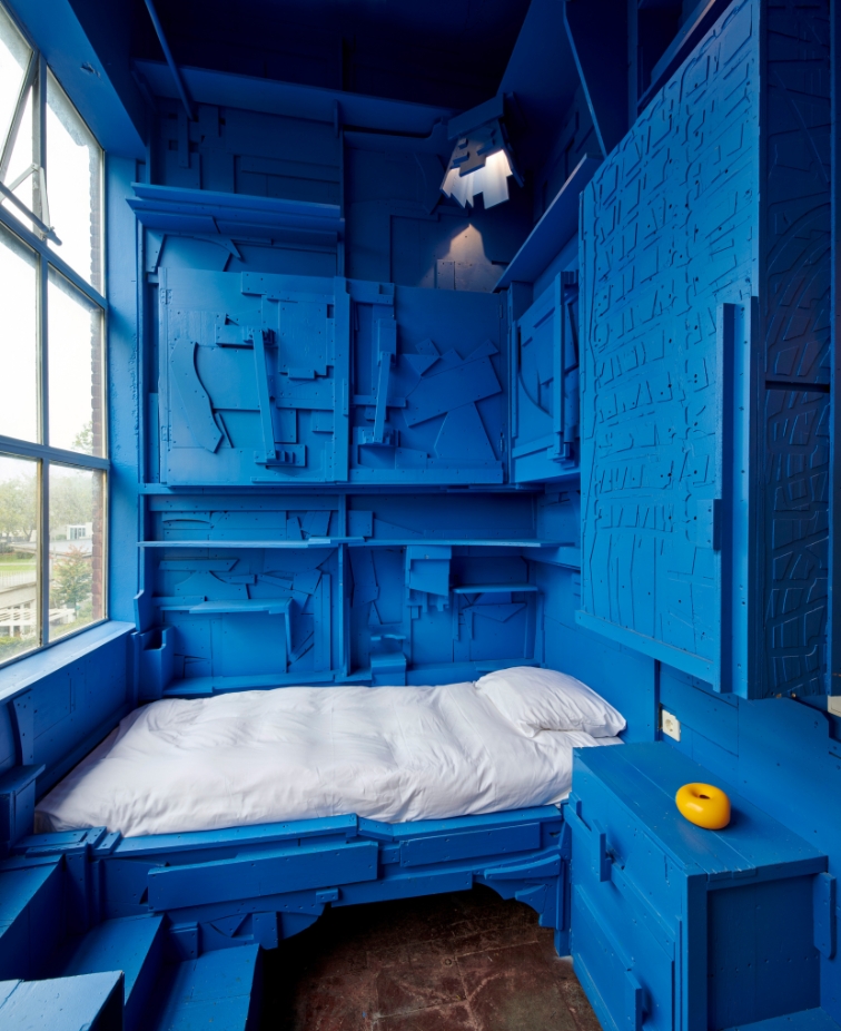 Een blauwe, houten hotelkamer met eenpersoonsbed ontworpen door Teun Zwets voor Hotel Piet Hein Eek.