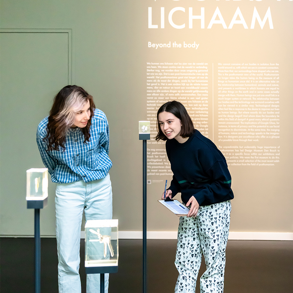 Twee studenten bekijken aandachtig een object in het museum.