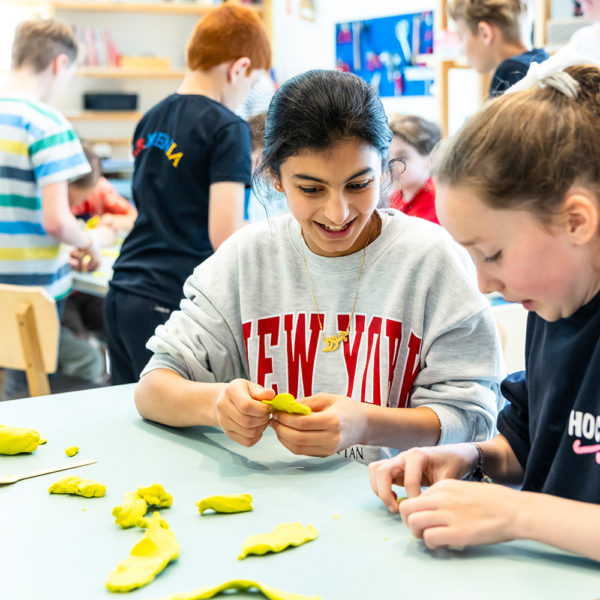 Twee meisjes uit groep 7 zijn samen aan het kleien tijdens de DesignWorkout in het museum.